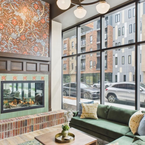 Find your home near Downtown Indy Clubhouse with wallpaper fireplace and green velvet couch
