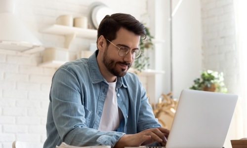 Apply to our Herron Morton community Man with glasses on computer